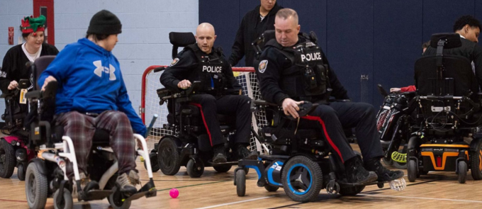 OPWHL players and members of the Ottawa Police Service share the floor during the OPWHL Holiday Celebration & Celebrity Game at the Greenboro Community Centre.